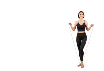 young beautiful woman in black leggings and top doing fitness and yoga indoors, on a white background, isolate
