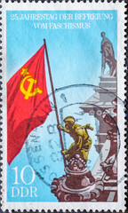 GERMANY, DDR - CIRCA 1970: a postage stamp from Germany, GDR showing soldier of the Red Army hoists the Soviet flag on the Reichstag building, Berlin. Text: 25th anniversary of liberation from fascism