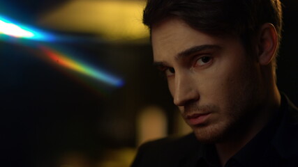 Rich guy looking camera indoors. Elegant man posing in dark interior.