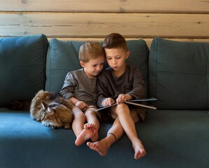 two boys are sitting on the couch