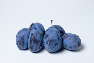 Plum on a white background. Several plums are in a heap. Healthy fruits.