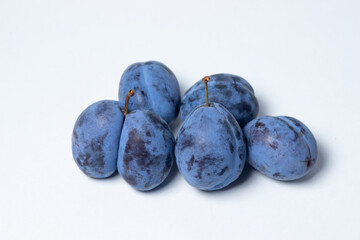 Plum on a white background. Several plums are in a heap. Healthy fruits.