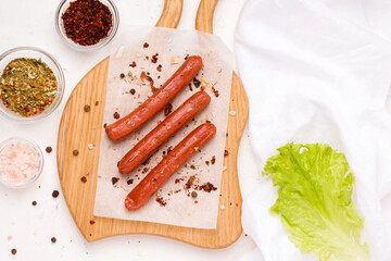 Vegan sausages with spices and tomato on a white plate. Copy space.