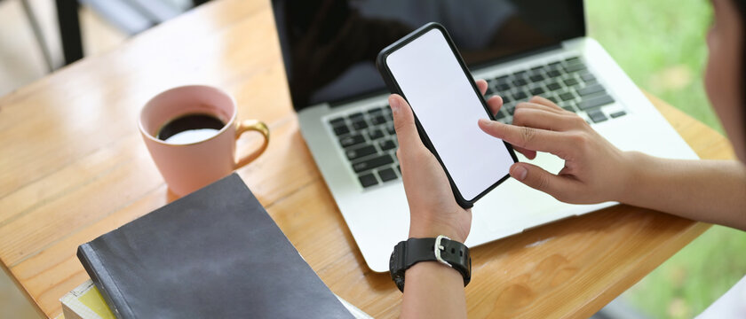 Woman hands holding smart phone with blank copy space screen for your text message or information content.