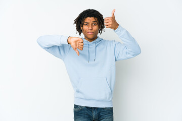 Young african american rasta man showing thumbs up and thumbs down, difficult choose concept