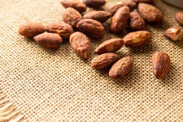 Heap of almond nuts on burlap background