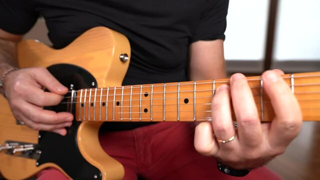 MANI DI UOMO ADULTO SUONANO CHITARRA ELETTRICA FACENDO ARPEGGI E NOTE MUSICALI 