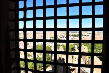 Barred window of the castle of Belmonte and the town in the background.