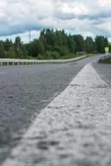 Long white stripe as road markings. The road to the distance.