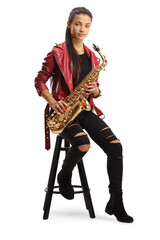 Naklejka premium Full length portrait of a young woman sitting on a chair and holding a saxophone