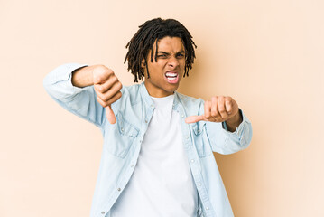 Young african american rasta man showing thumb down and expressing dislike.