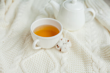 Obraz na płótnie Canvas A mug of hot tea on a knitted blanket. Cozy autumn. Winter breakfast. Cotton.