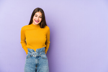 Young caucasian woman isolated on purple background happy, smiling and cheerful.