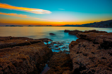 Long exposure sunset from the rocks on the coastline with a colorful horizon