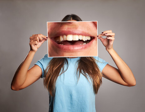 woman holding a picture of a mouth smiling