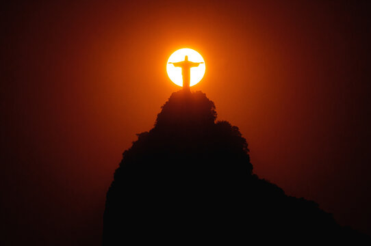 Rio de Janeiro, Brazil - February 1, 2019: Famous Christ the Redeemer statue on the Corcovado mountain with Sun right behind it.