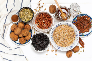 Ingredients for making granola. Rolled oats, nuts, berries and honey on a white background top view.  Tasty and healthy food.