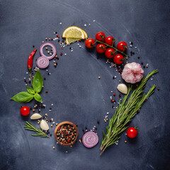 Herbs and condiments on black stone background.