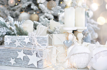 Beautiful Christmas card. Christmas background 2021. White Christmas balls, box with gifts, candle on the background of the Christmas tree