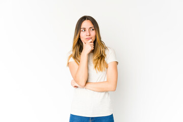 Young caucasian woman isolated on white background looking sideways with doubtful and skeptical expression.