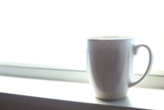 Coffee mug on a bright white windowsill
