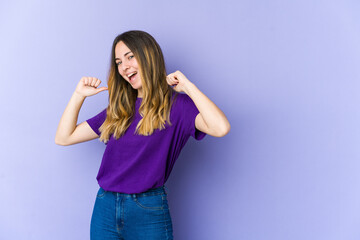 Young caucasian woman isolated on purple background feels proud and self confident, example to follow.