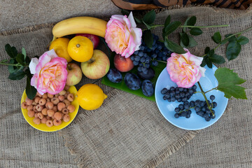 On the saucers and on the table are yellow raspberries, grapes, apples, lemons, reputations,...
