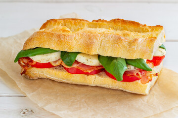 Caprese sandwich with tomatoes, mozzarella, basil and bacon. Healthy eating. Italian cuisine.