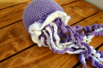 Crochet toy for children octopus on a wooden background.