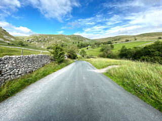 Travelling down Gordale Lane, with dry stone walls, grass, and fields in the distance in, Malham, Skipton, UK