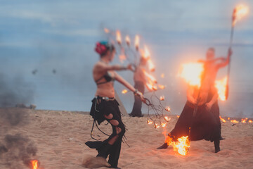 Group of fire artists fakir perform amazing show at night with flamethrowers, fire dancers, chain...