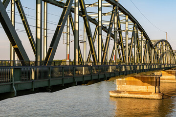 Iron railroad bridge over the Danube river in Vienna at sunset