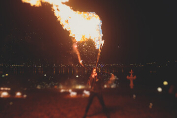 Group of fire artists fakir perform amazing show at night with flamethrowers, fire dancers, chain of fire, extreme breathing