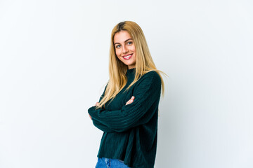 Naklejka premium Young blonde woman isolated on white background who feels confident, crossing arms with determination.