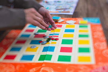 Fototapeta premium Process of playing retro vintage old style board game and having fun with friends and family, board game concept, hand playing and roll the dice