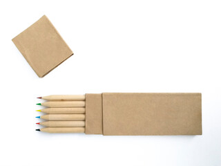 Aerial view of wooden pencils with colored tips in horizontal position and recycled paper case isolated on white. Crayons with eco-friendly cover. School supplies and back to school pattern.