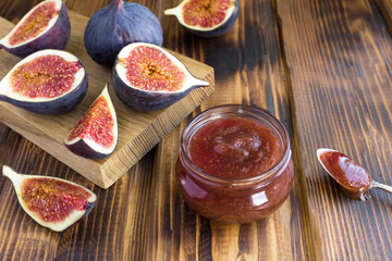 Fig jam in the glass jar on the brown wooden table