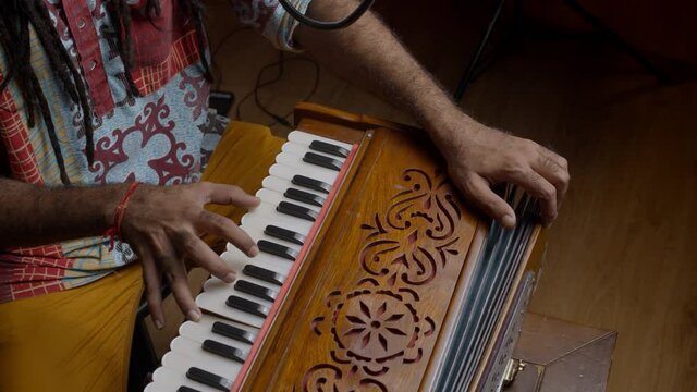 Traditional world. Folk instrument. Indian man playing harmonium in the sound studio. Hindi male person plays meditation music.