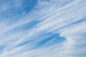 Beautiful blue sky background. Soft white clouds with patterns at sunset