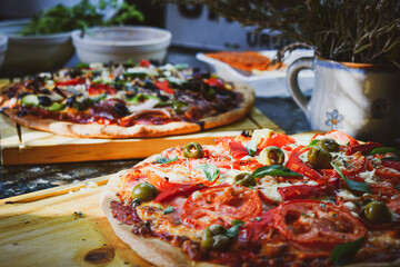 Dos pizzas hechas en casa estilo uruguayas con diferentes ingredientes 