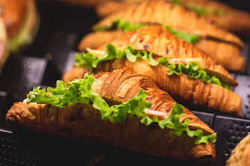 Beautifully decorated catering banquet table with different food snacks and appetizers with sandwich, burger and croissant  on corporate christmas birthday kids party event or wedding celebration