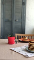 Plate with stack of homemade pancakes and sour cream on wooden table, selective focus