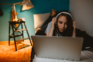 young woman relaxing in her apartment using laptop computer