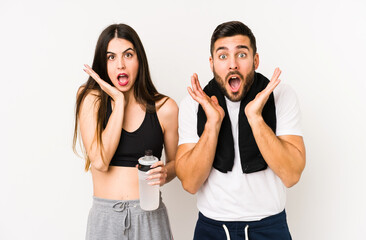 Young caucasian fitness couple isolated surprised and shocked.