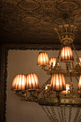 Large bronze vintage chandelier on white wall background