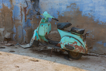 Beautiful old retro scooter. Indian travel. Blue streets in Rajasthan, bike near the wall. Jodhpur