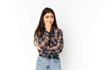 Young indian woman isolated on purple background biting fingernails, nervous and very anxious.
