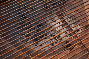 Culinary equipment. Closeup view of an iron grill for cooking. Red and brown rusty texture and pattern. 
