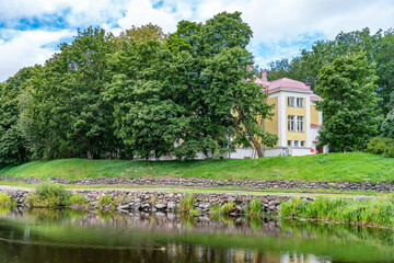 Fototapeta na wymiar Old yellow house near pond