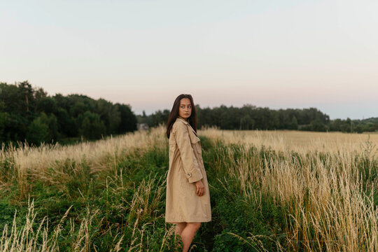 woman in a meadow in a raincoat